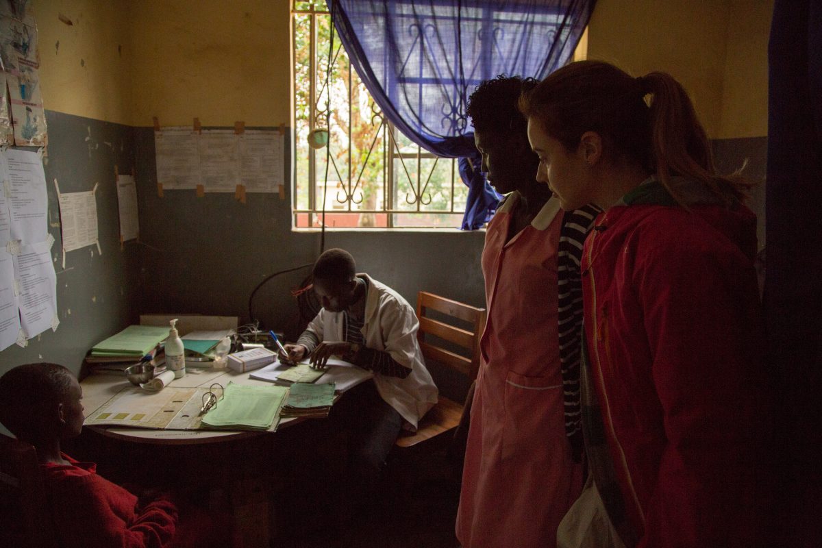 women looking at doctor writing notes